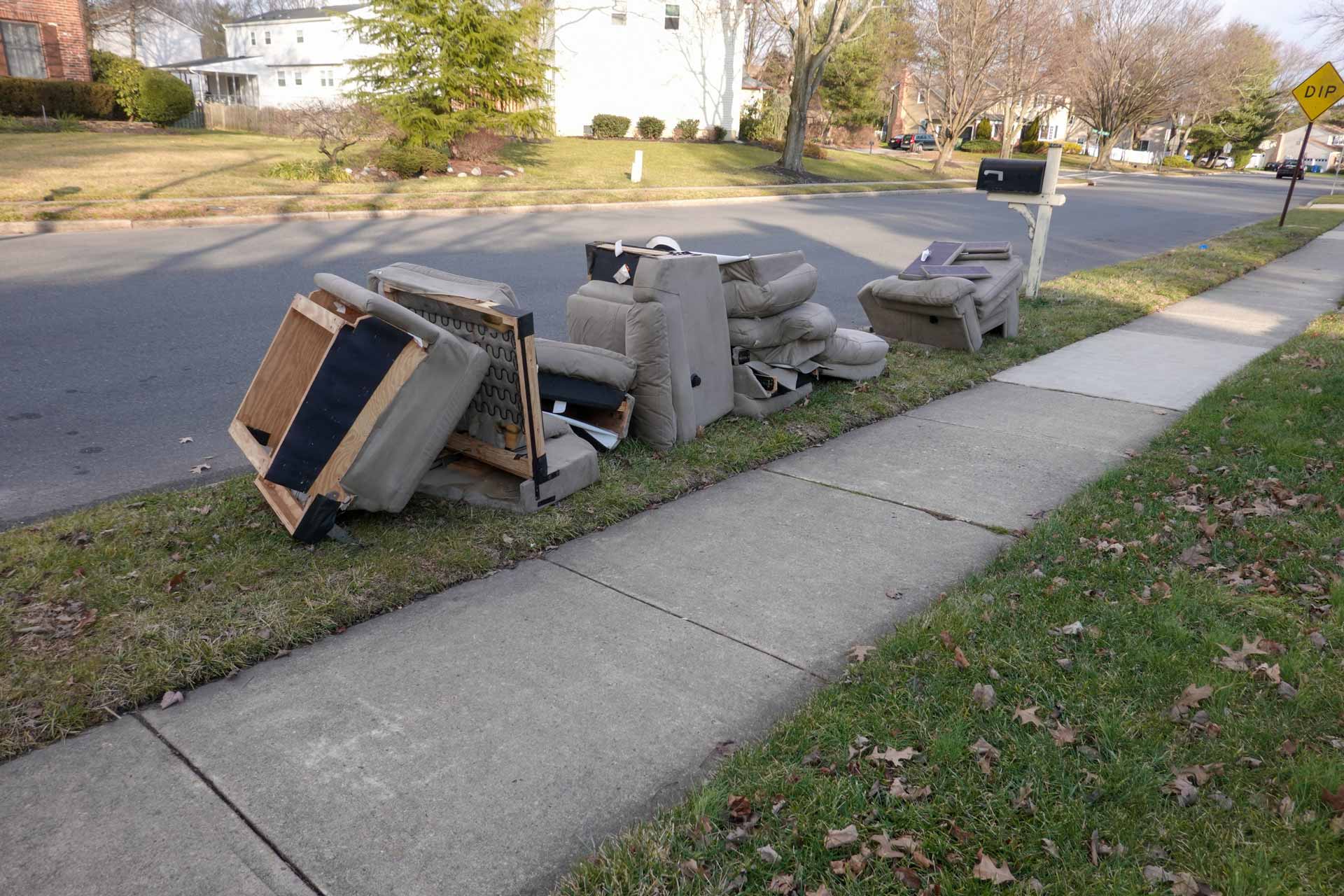 Furniture piled at curb in residential neighborhood