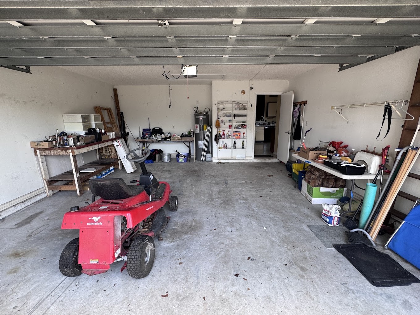 A garage with some old junk and a lawnmower inside