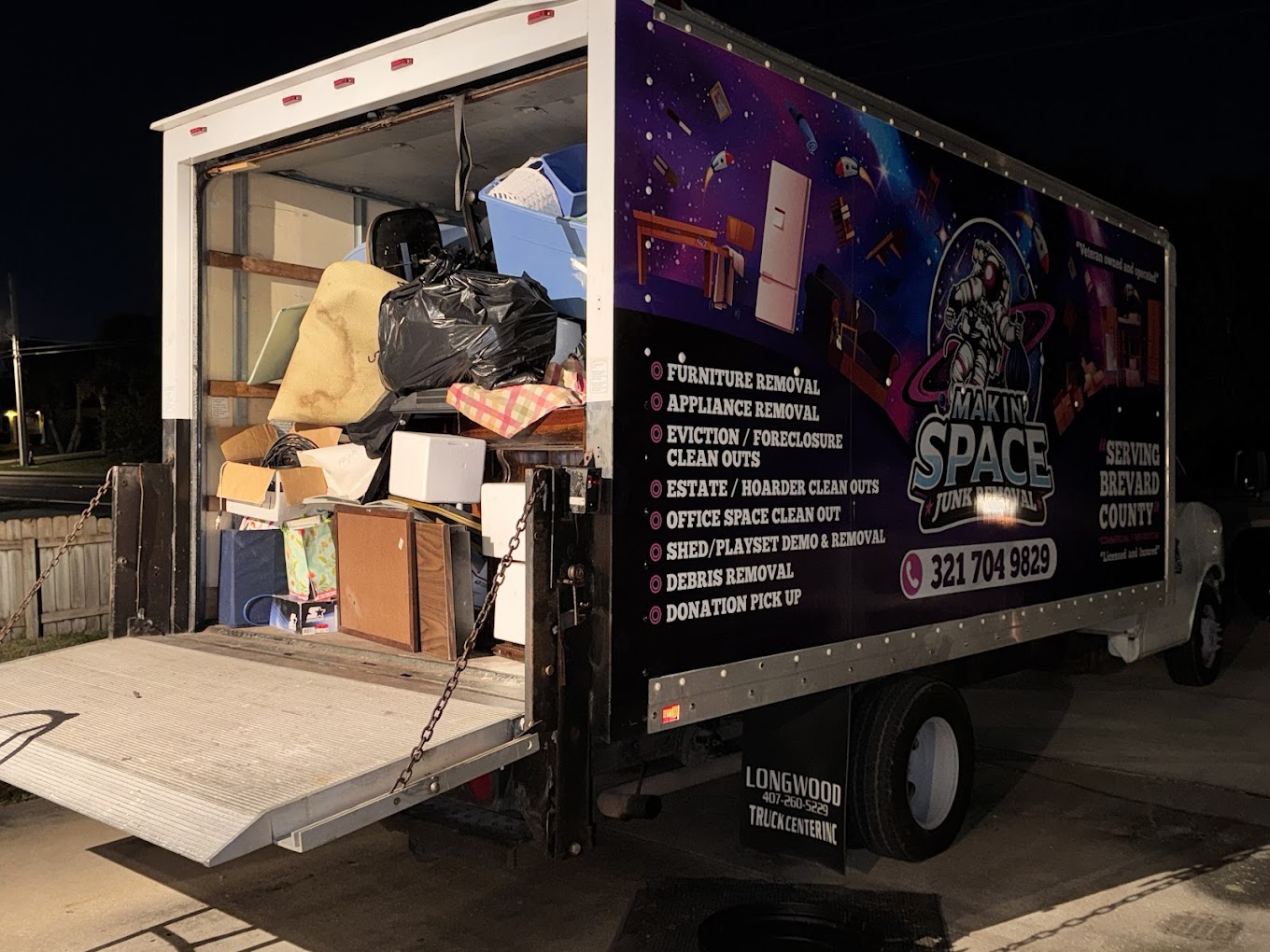 Makin' Space Junk Removal truck with the back open, showing it is full of junk