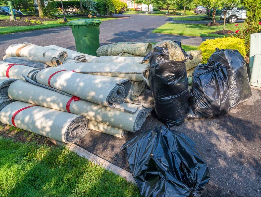 Old carpet rolls and other trash at the curb
